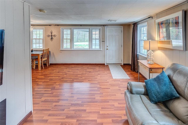 living room featuring wood-type flooring and wooden walls