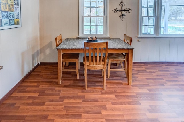 dining room featuring wooden walls and hardwood / wood-style flooring