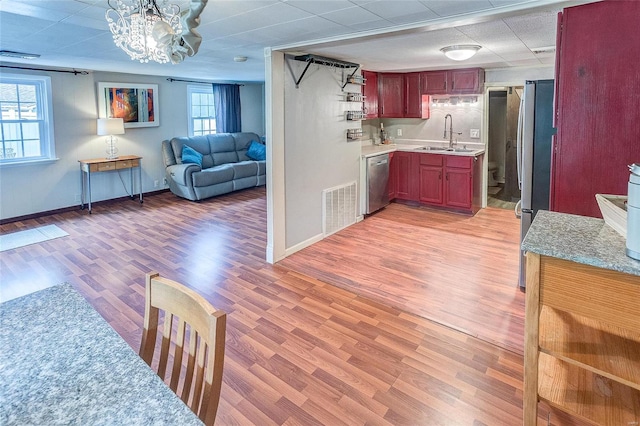 kitchen featuring appliances with stainless steel finishes, plenty of natural light, light hardwood / wood-style floors, and sink