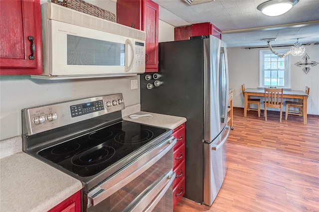 kitchen featuring light hardwood / wood-style flooring, an inviting chandelier, and stainless steel appliances