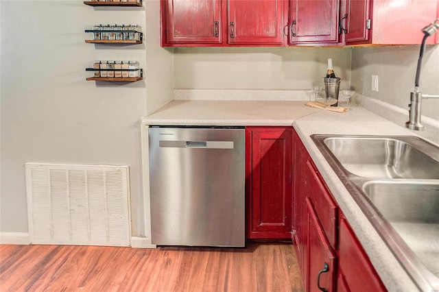 kitchen with dishwasher, hardwood / wood-style floors, and sink