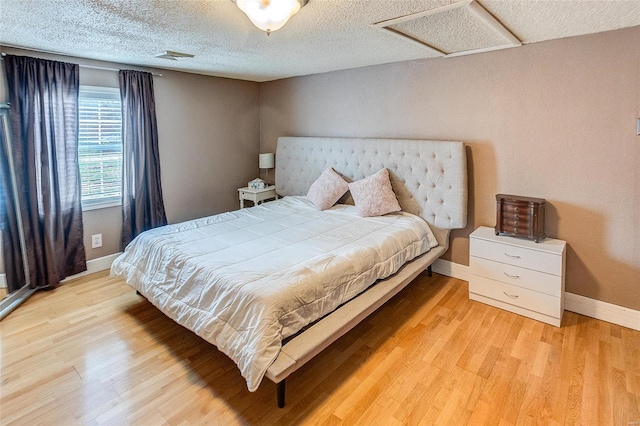 bedroom featuring light wood-type flooring and a textured ceiling