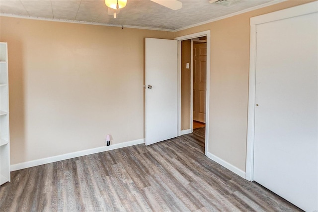 unfurnished bedroom featuring hardwood / wood-style floors, ceiling fan, and crown molding