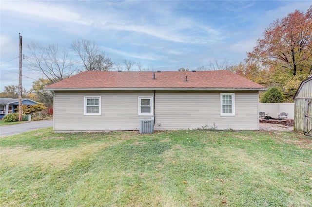 back of property featuring central AC and a yard