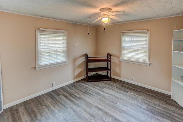 unfurnished room featuring wood-type flooring, plenty of natural light, and crown molding