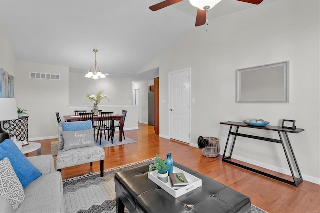 living room with hardwood / wood-style flooring and ceiling fan with notable chandelier