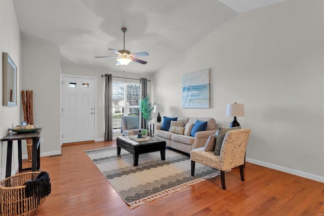 living room with light hardwood / wood-style floors, ceiling fan, and lofted ceiling