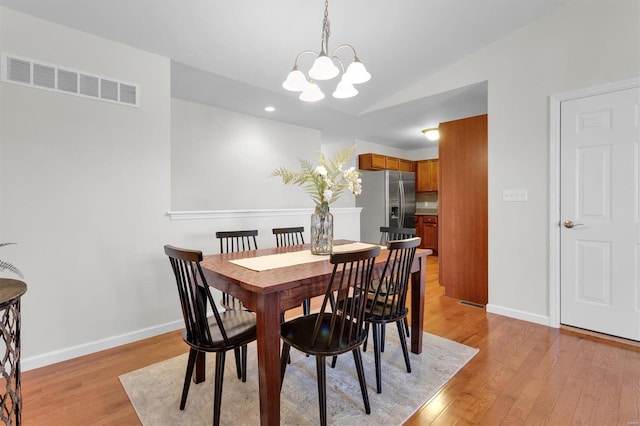 dining space with a chandelier and light wood-type flooring