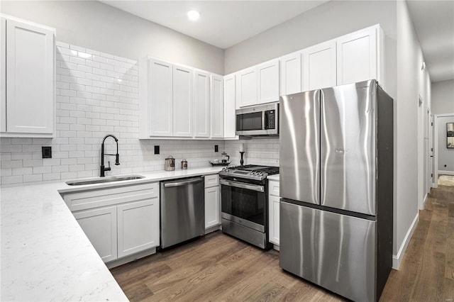 kitchen with dark hardwood / wood-style flooring, white cabinets, sink, and stainless steel appliances