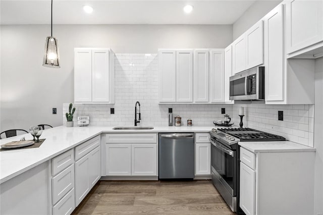 kitchen with pendant lighting, white cabinetry, appliances with stainless steel finishes, and sink