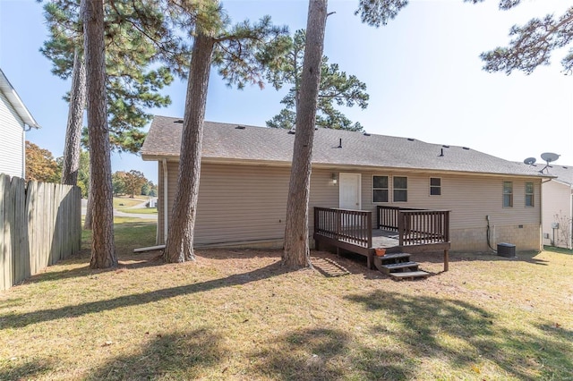 rear view of house with a yard and a wooden deck