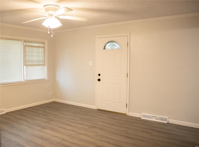 foyer entrance featuring ornamental molding, a textured ceiling, dark wood-type flooring, and ceiling fan