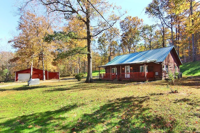 view of yard with covered porch, an outbuilding, and a garage