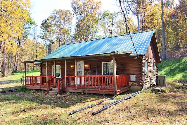 log cabin with a porch, a front yard, and central AC unit