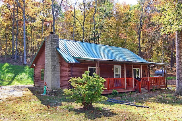 cabin featuring a front yard and covered porch