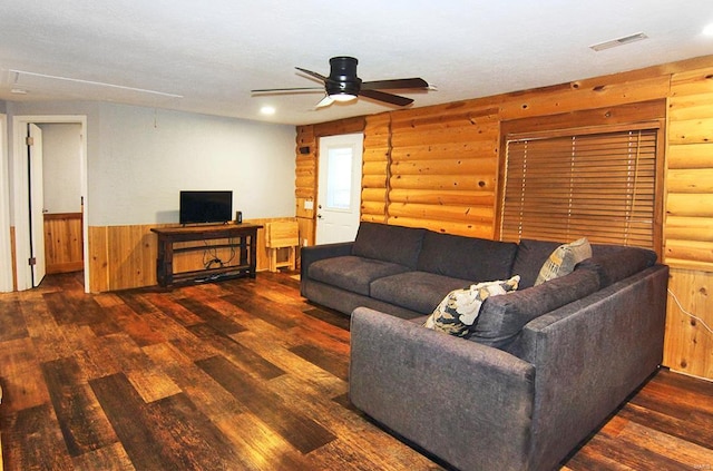 living room featuring log walls, ceiling fan, and dark hardwood / wood-style flooring