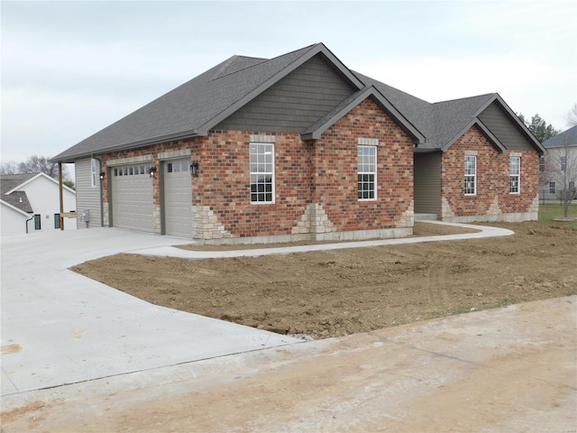 view of front of house with a shingled roof, concrete driveway, brick siding, and an attached garage