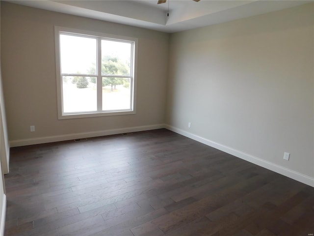 unfurnished room with dark wood-style flooring, ceiling fan, and baseboards