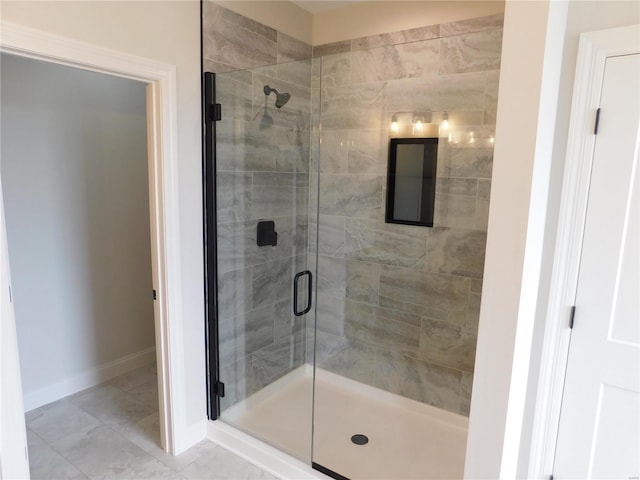 bathroom featuring a shower stall and baseboards