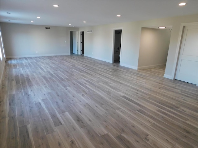 empty room with visible vents, baseboards, wood finished floors, and recessed lighting