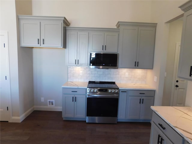 kitchen featuring stainless steel appliances, dark wood-style flooring, gray cabinets, and backsplash