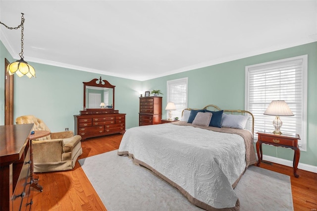 bedroom with crown molding and hardwood / wood-style flooring