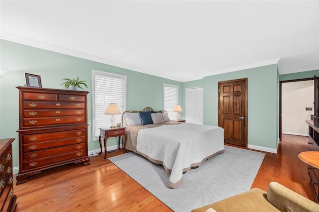 bedroom with crown molding, wood-type flooring, and a closet