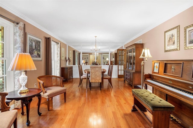 dining area featuring ornamental molding, a chandelier, and light wood-type flooring