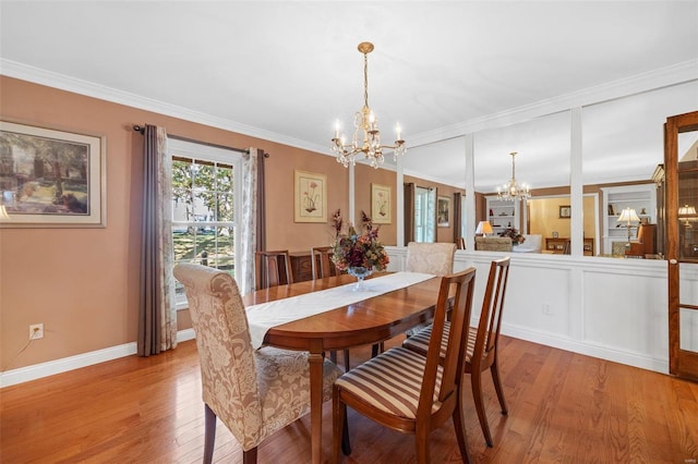 dining space featuring an inviting chandelier, crown molding, and light hardwood / wood-style flooring