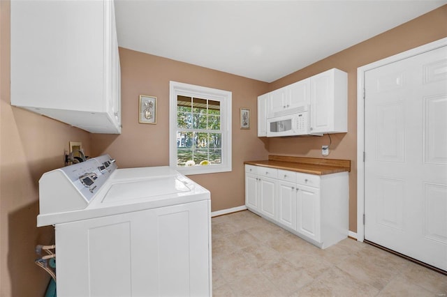 washroom with washer and dryer and cabinets