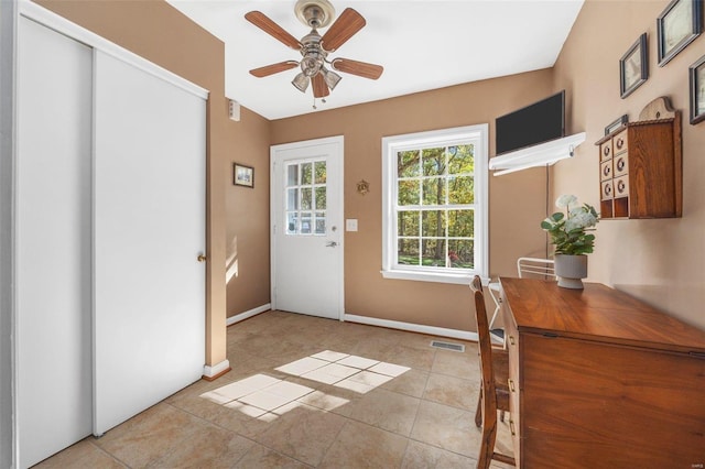 entryway with light tile patterned floors and ceiling fan