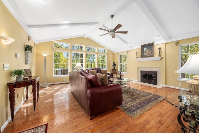 living room featuring light hardwood / wood-style flooring, lofted ceiling with beams, and ceiling fan