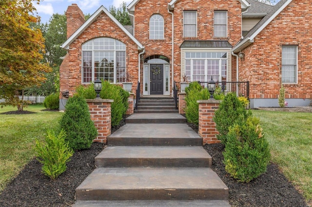 entrance to property featuring a lawn