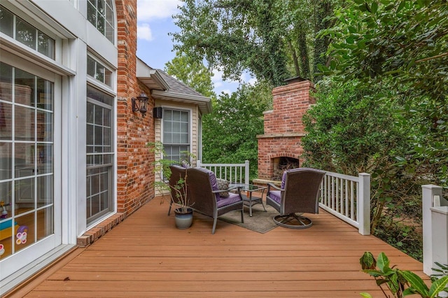 wooden deck with an outdoor brick fireplace