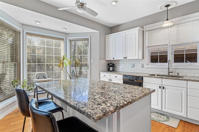 kitchen with white cabinetry, black dishwasher, sink, and pendant lighting