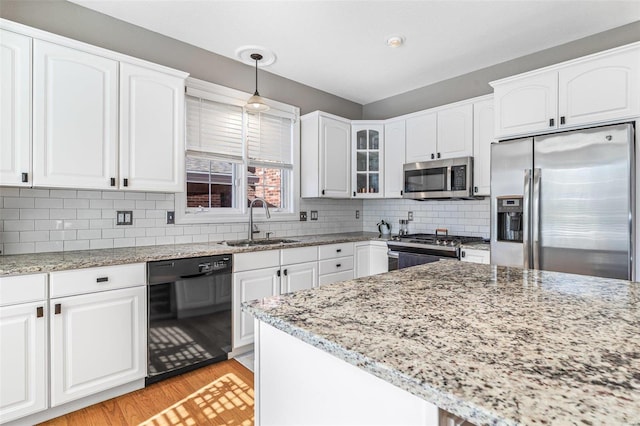 kitchen featuring white cabinets, hanging light fixtures, stainless steel appliances, and sink