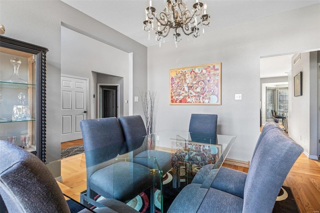 dining space featuring hardwood / wood-style flooring and an inviting chandelier