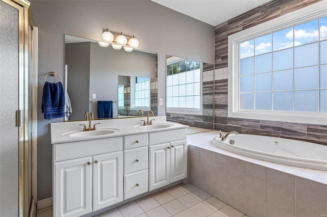 bathroom with vanity, a relaxing tiled tub, and tile patterned floors