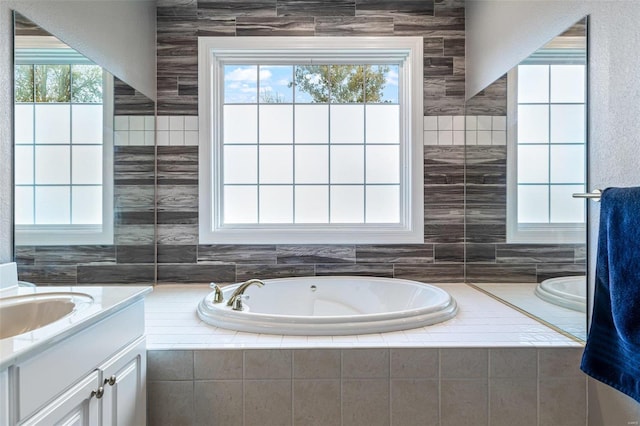 bathroom featuring vanity and a relaxing tiled tub