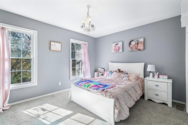 carpeted bedroom featuring an inviting chandelier and multiple windows