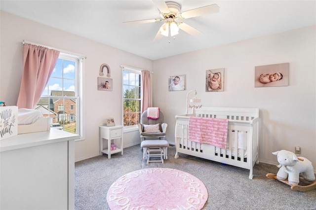 bedroom with a nursery area, carpet, and ceiling fan