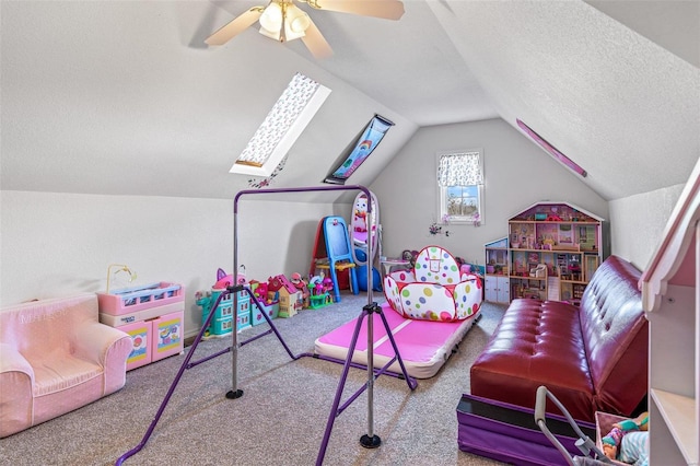 recreation room featuring lofted ceiling with skylight, a textured ceiling, and carpet flooring