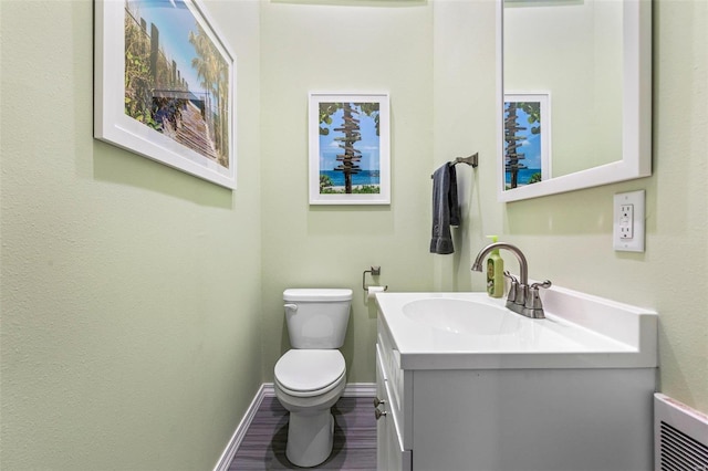 bathroom featuring vanity, wood-type flooring, and toilet