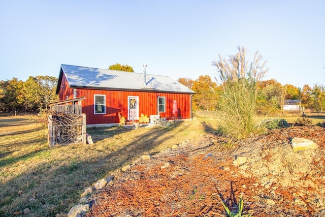 rear view of house with a yard and an outdoor structure