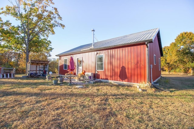 rear view of house with an outdoor structure and a yard