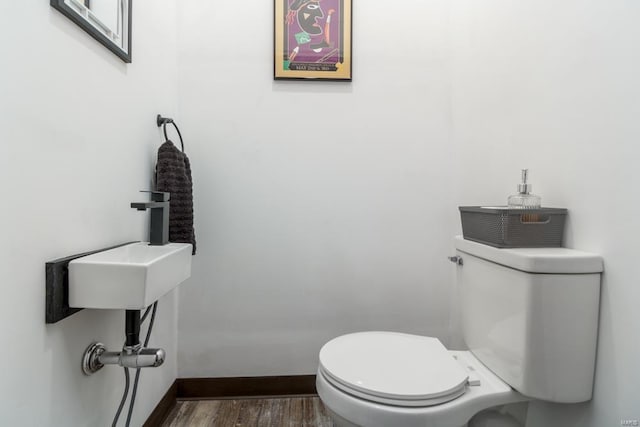 bathroom featuring wood-type flooring and toilet