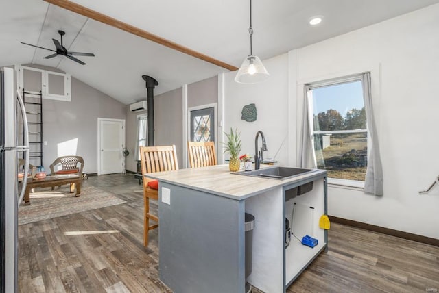 kitchen with pendant lighting, dark hardwood / wood-style floors, stainless steel fridge, and sink