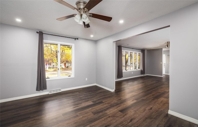 spare room with dark wood-type flooring, ceiling fan, and a textured ceiling