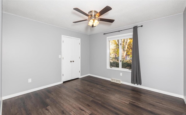 empty room featuring dark hardwood / wood-style floors, a textured ceiling, and ceiling fan