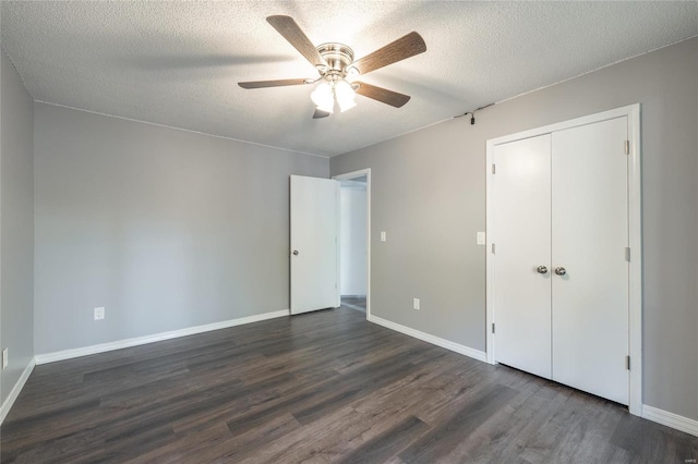 unfurnished bedroom with dark hardwood / wood-style flooring, a closet, a textured ceiling, and ceiling fan